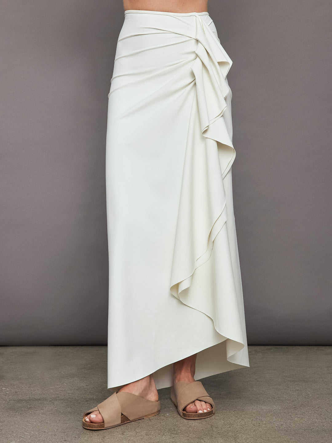 A high-waisted, midi-length white skirt with pleats.