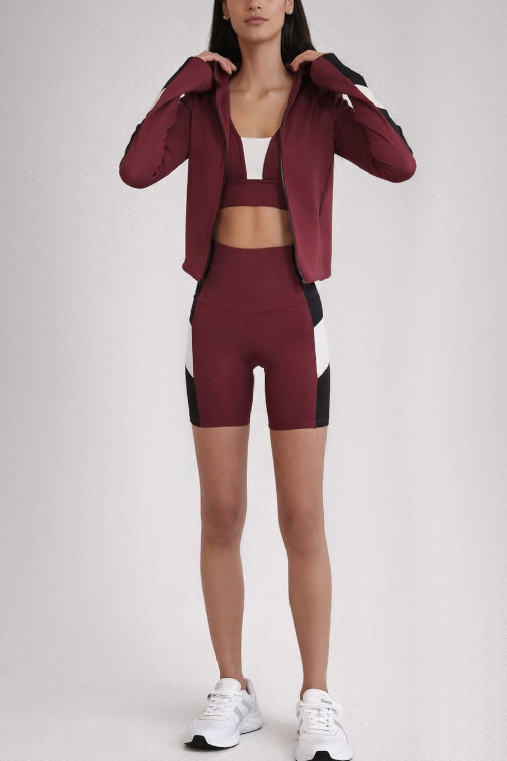 Person wearing a maroon athletic outfit with a white background