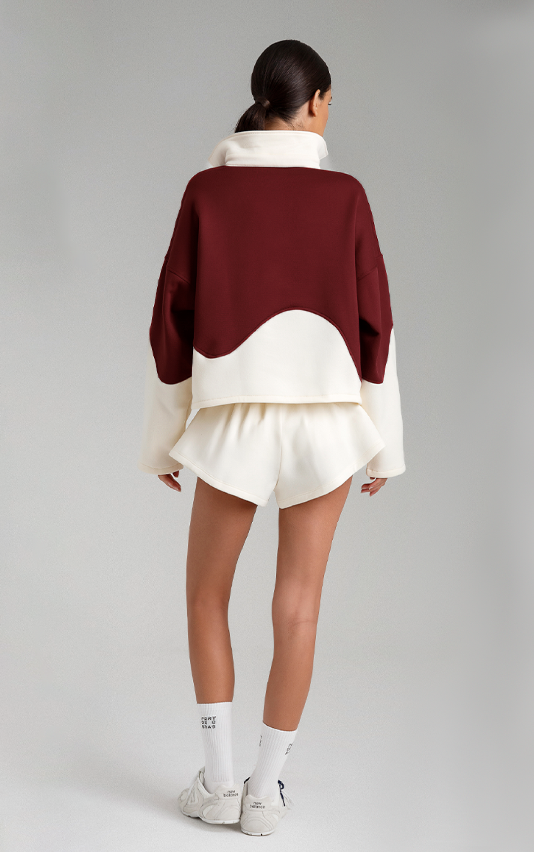 Person wearing a burgundy and white outfit on a gray background